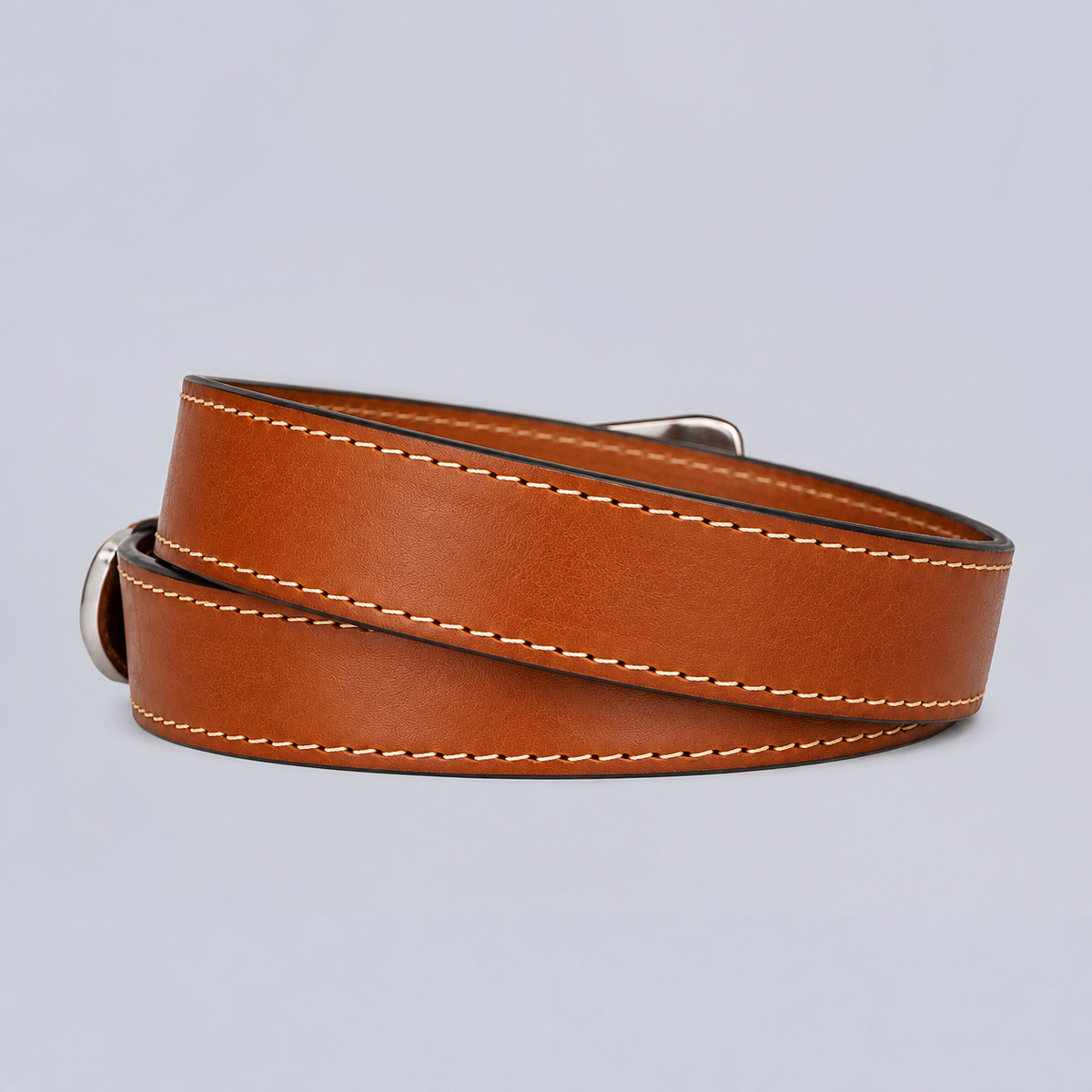 Coiled brown leather The Xtreme - 1.5″ concealed carry belt with light-colored stitching and a metal buckle.
