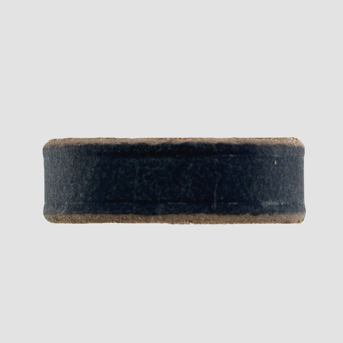 A close-up of a round, flat hockey puck on a white background, its smooth finish and dark color reminiscent of the durable Hanks Belts 1.5" Crazy Horse #9 Keeper.