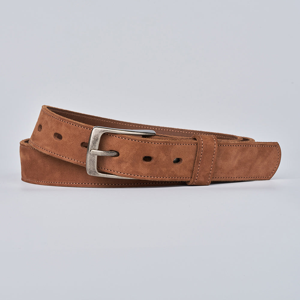 The Suede - 1.25" by Hanks Belts, a brown suede leather belt with a silver metal buckle, is shown coiled on a plain light gray background.