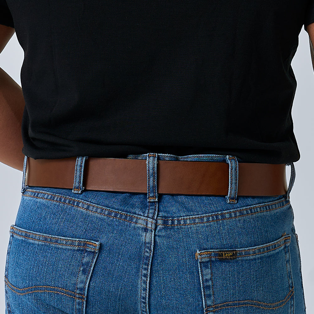 A person wearing a black shirt tucked into blue jeans with The Enforcer 1.75" CCW belt by Hanks Belts, shown from the back waist down.