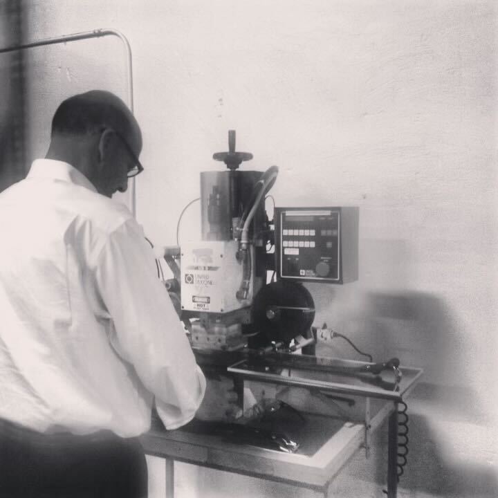 Early 2000's. Person operating a machine with a control panel in a workshop setting Text below the image: Hank’s welcomes the new century with the expansion into another new location, specializing in workwear and footwear. A separate department is given to our USA Made belts and leather products, which have grown to be items of very high demand. Designed and specked in house, they were soon to become the future of the business. 
