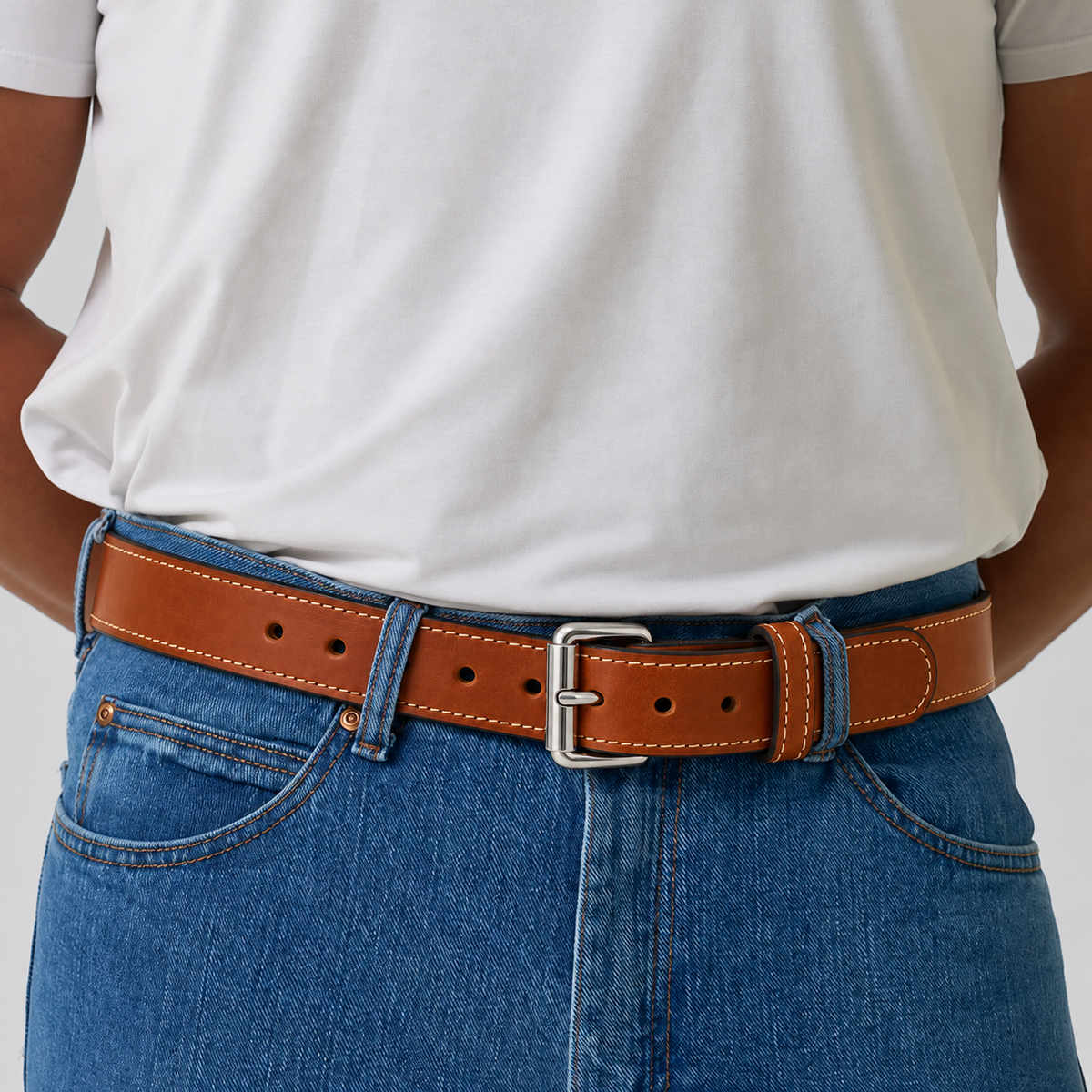 Tan leather The Xtreme - 1.5″ concealed carry belt with a silver buckle worn over blue jeans.