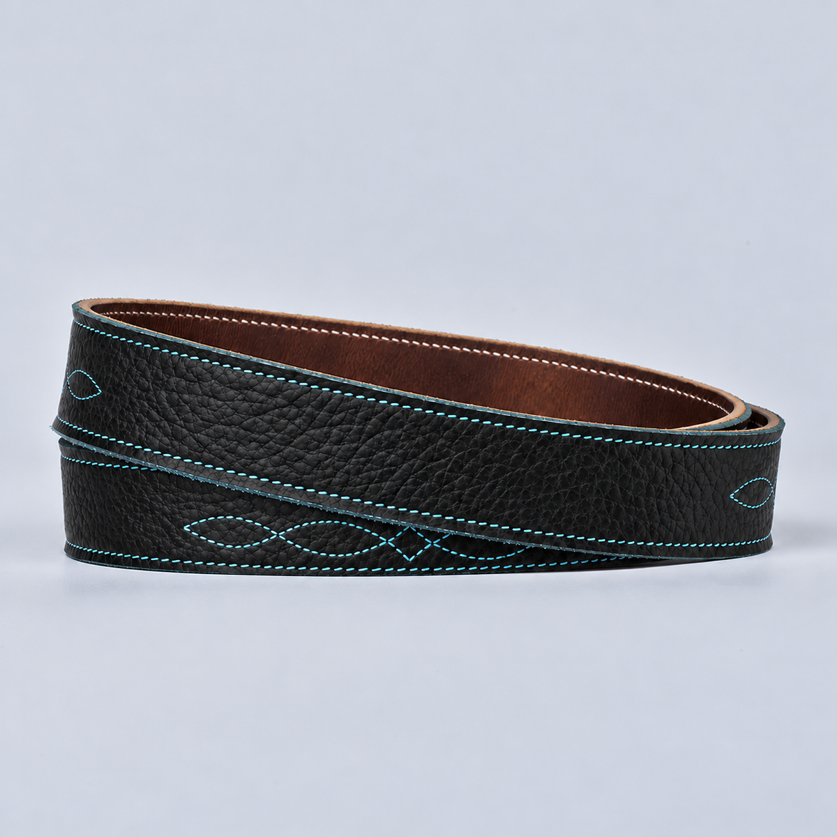 The Yellowstone for Women 1″ with Stitched Center: coiled black bison leather belt with teal stitching on a light background.